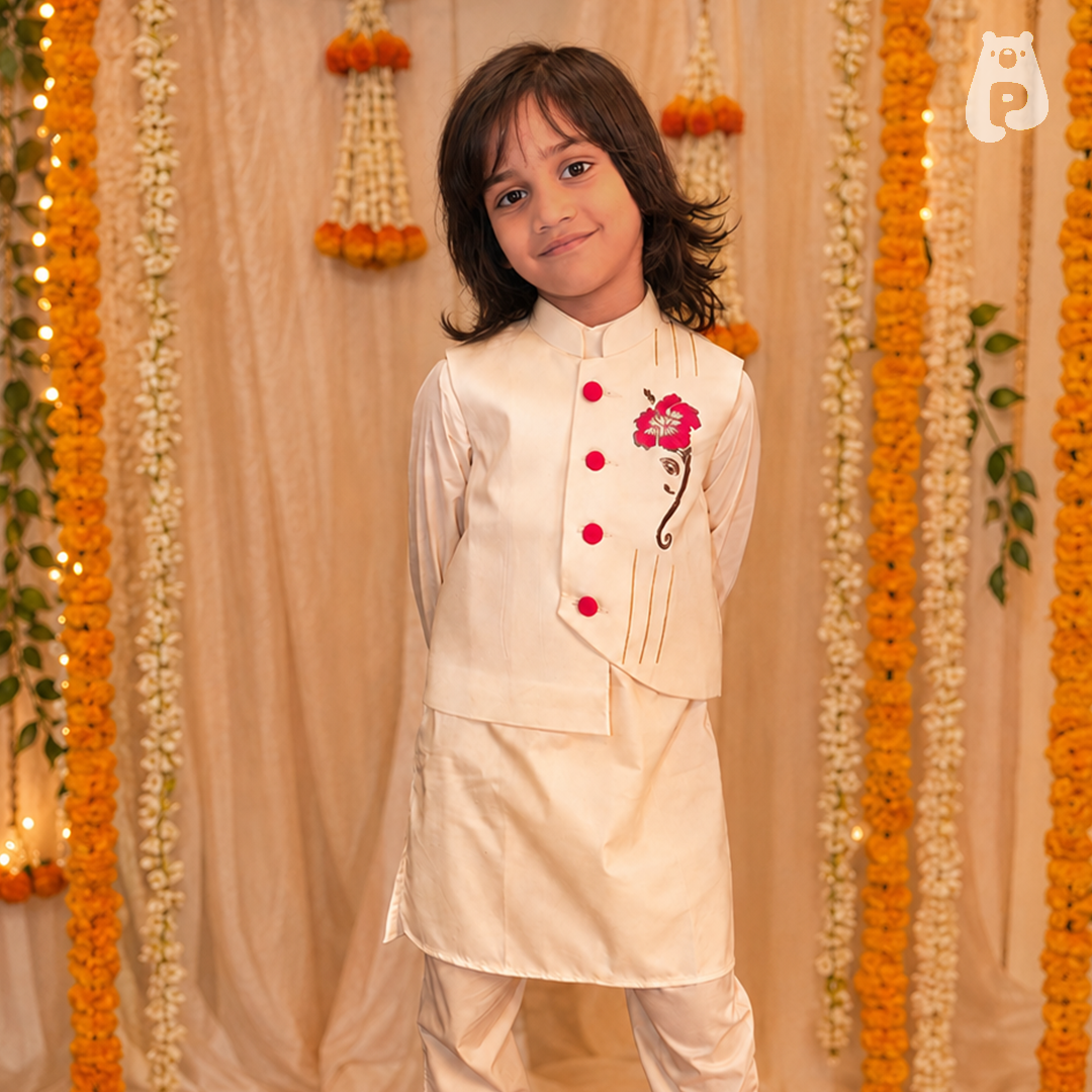 Boy wearing an off-white kurta set with asymmetrical jacket and Ganesh embroidery